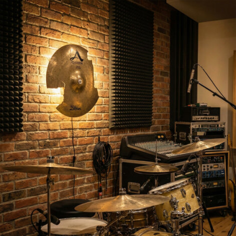 Pendant lamp made from a recycled bronze drum cymbal, showing original cracks and a vintage golden finish.
