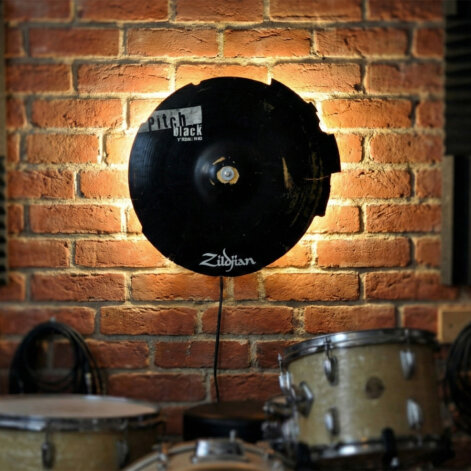 Pendant lamp made from a recycled bronze drum cymbal, showing original cracks and a vintage golden finish.